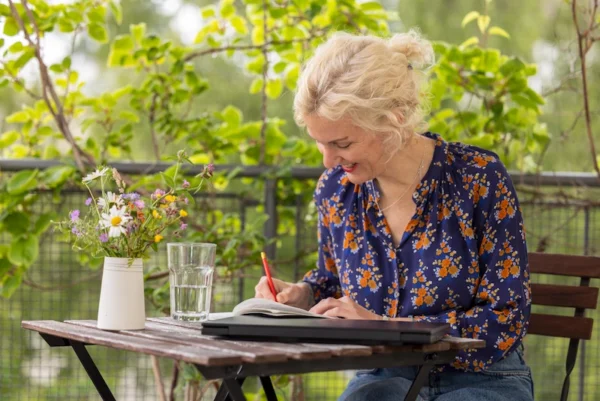 Sylvia sitzt am Tisch und schreibt